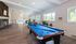 Spacious and elegant recreation room with billiards table, cozy seating, and large windows offering bright natural light.| The Royal Crest | Apartment in North Andover, MA