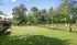 Inviting outdoor space featuring a fenced grassy area with sturdy benches, perfect for relaxation and play.| The Royal Crest | Apartment in North Andover, MA