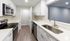 Sleek modern kitchen with stainless steel appliances, elegant white cabinetry, and chic wood-look flooring.Your spacious kitchen offers generous square footage with room for multiple people and all your cooking essentials.  | The Royal Crest | Apartment in,North Andover MA