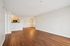Spacious open-concept living area with elegant wood flooring and a cozy kitchen with warm cabinetry.| Village Green | Apartment in Tewksbury, MA