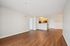 Bright and spacious open-plan living area with elegant hardwood floors and a modern kitchen, perfect for entertaining.| Village Green | Apartment in Tewksbury, MA