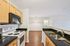 Modern kitchen with sleek black countertops, stainless steel appliances, and warm wooden cabinets, offering a spacious and inviting cooking space.| Village Green | Apartment in Tewksbury, MA