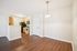 Inviting apartment space with warm hardwood floors, a well-lit dining area, and a modern kitchen featuring sleek appliances.| Village Green | Apartment in Tewksbury, MA