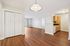Modern apartment interior showcasing a spacious open-concept dining area with elegant hardwood floors and a cozy kitchen featuring stylish cabinetry.| Village Green | Apartment in Tewksbury, MA