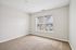 Bright and airy bedroom with plush carpet and large window offering an inviting view, perfect for relaxation.| Village Green | Apartment in Tewksbury, MA
