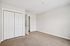 Bright and inviting room with plush carpet, sleek white double closet doors, and a modern open door, perfect for a cozy bedroom.| Village Green | Apartment in Tewksbury, MA