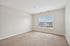Bright and spacious bedroom with plush carpet, large window, and abundant natural light.| Village Green | Apartment in Tewksbury, MA