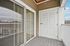 Charming apartment balcony with sliding glass doors and a classic wooden railing, offering serene outdoor relaxation space.| Village Green | Apartment in Tewksbury, MA