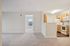 Bright apartment with open-plan design, featuring a cozy kitchen with wood cabinetry and an inviting living area leading to a sunlit bedroom.| Village Green | Apartment in Tewksbury, MA