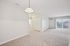 Modern open-plan apartment with spacious living area, large windows for ample natural light, and sleek lighting fixture.| Village Green | Apartment in Tewksbury, MA