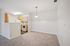Inviting apartment interior with a modern kitchen, cozy carpeted dining area, and sleek lighting.| Village Green | Apartment in Tewksbury, MA
