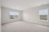 Bright and spacious empty room with large windows inviting natural light, perfect for personalization and creating a cozy atmosphere.| Village Green | Apartment in Tewksbury, MA