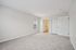 Bright and spacious bedroom with plush carpet, large window, and convenient en-suite bathroom access, offering a serene and inviting living space.| Village Green | Apartment in Tewksbury, MA