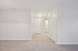Inviting entryway with plush carpeting, ample closet space, and a glimpse of a bright utility area.| Village Green | Apartment in Tewksbury, MA
