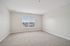Bright, spacious bedroom with plush carpeting and a large window offering scenic views, perfect for relaxation.| Village Green | Apartment in Tewksbury, MA