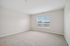 Bright and spacious room with large window and plush carpet, offering a cozy and inviting atmosphere.| Village Green | Apartment in Tewksbury, MA