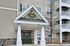 The main entrance showcases a clean, contemporary design with glass doors and bright lighting for a warm welcome home. | Village Green | Apartment in Tewksbury, MA