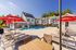 Dive into relaxation in our sparkling swimming pool surrounded by premium deck furniture and refreshing shade structures. | Mill & 3 Apartments | Mill & 3 Apartments Apartments