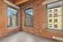 Your charming loft apartment features exposed brick walls and large windows that fill the space with abundant natural light overlooking a vibrant urban street. | 381 Congress Lofts | Apartments For Rent in Boston