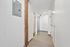 Welcome home through a beautifully designed modern hallway, showcasing sleek light wood floors and a rustic wooden beam for a chic industrial aesthetic. | 381 Congress Lofts | Apartments For Rent in Boston