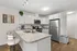 Modern kitchen with sleek stainless steel appliances, elegant white cabinetry, and a stylish granite countertop island with bar seating.