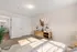 Bright and inviting bedroom with chic decor, featuring ample natural light, modern furniture, and elegant artwork for a serene living space.