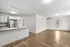 Bright and modern open-concept living area with a sleek kitchen, featuring hardwood floors, stainless steel appliances, and abundant natural light.