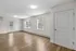 Bright and spacious living area with sleek hardwood floors, large windows, and a modern doorway leading to a private balcony.