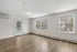 Bright and inviting living room with natural light from large windows, featuring elegant wood flooring and modern finishes.