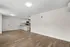 Contemporary open-plan living room with sleek hardwood floors and a modern kitchen space.