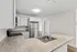 Modern kitchen with sleek stainless steel appliances, granite countertops, and elegant white cabinetry offering ample storage space.
