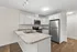 Modern kitchen with sleek stainless steel appliances, elegant white cabinetry, and a spacious granite countertop, perfect for culinary enthusiasts.