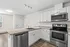 Bright and modern kitchen with sleek stainless steel appliances, elegant granite countertops, and ample white cabinetry.