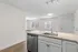 Bright and airy open-concept kitchen with sleek countertops and stainless steel appliances, basking in natural light through large windows.
