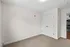 Bright and inviting room with plush carpet and double-door closet, adjacent to a modern kitchen.