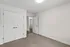 Bright and airy room with plush carpet, modern white doors, and a sleek open entryway showcasing contemporary design.