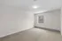 Bright, spacious room with soft carpeting and a large window offering serene views, perfect for a cozy retreat.