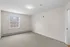 Bright and inviting empty room with plush carpet, large window offering natural light, and fresh neutral walls.