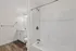 Modern bathroom with sleek fixtures, including a bathtub, elegant vanity, and warm wood flooring.