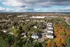 Breathtaking aerial view of a vibrant suburban neighborhood surrounded by lush autumn foliage, offering a serene and picturesque living environment.