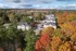 Scenic aerial view of charming residential apartments nestled among vibrant autumn trees, offering a picturesque suburban setting.