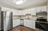 Modern kitchen with sleek stainless steel appliances, elegant white cabinetry, and granite countertops, perfect for culinary enthusiasts.