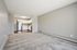 Spacious living area with plush carpet and a modern kitchen featuring stainless steel appliances and stylish cabinetry.