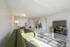 Bright and modern living room with a stylish green sofa, glass coffee table, and elegant dining area perfect for entertaining.