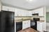 Modern kitchen with sleek black appliances, elegant white cabinetry, and stylish marble countertops.