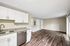 Bright, open-concept living area featuring modern kitchen with granite countertops, stainless steel appliances, and sleek wooden flooring.