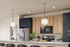 Princeton Wilmington Apartments | Modern kitchen with sleek appliances, stylish pendant lights, and a sophisticated blend of wood and navy cabinetry. | New Construction for Rent in Massachusetts