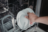 Modern dishwasher interior with silverware basket and plates, showcasing efficient kitchen convenience.