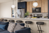 Luxurious open kitchen with sleek modern appliances, elegant pendant lighting, and stylish breakfast bar seating, perfect for entertaining.