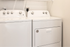 Sleek and modern laundry room featuring state-of-the-art washer and dryer units with convenient shelving.